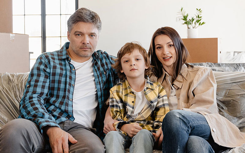 family of three sitting in the couch